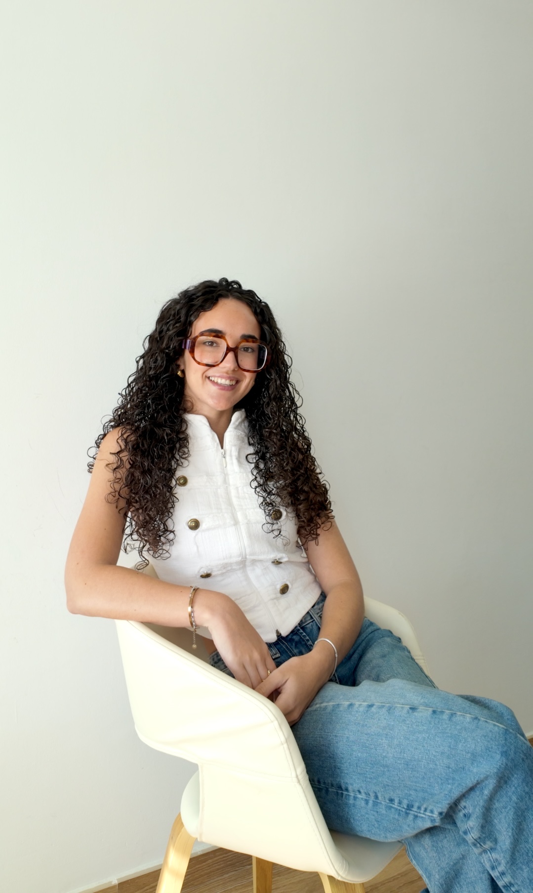 Paula Mateu sentada en una silla blanca, sonriendo